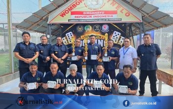 Foto kelompok pemenang turnamen domino di Lapas Pohuwato, memegang trofi dan piagam penghargaan