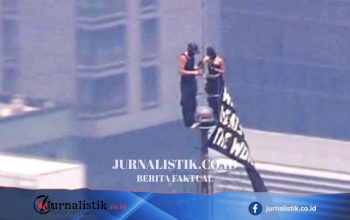 Dua Orang Naik ke Puncak Empire State Building, Spanduk “When the power of love beats the love of power the world knows peace”